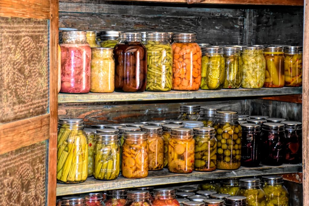 a wooden shelf filled with lots of jars of food